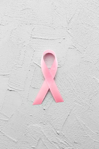 Free photo breast cancer ribbon on plaster background