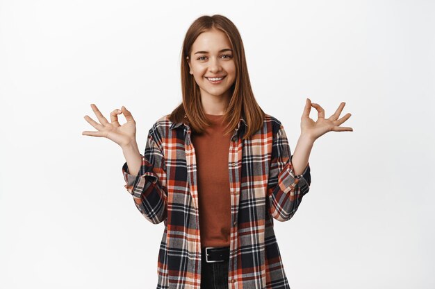 Breath and relax. Smiling young calm woman, girl meditate, practice yoga, hold hands in zen, mudra sign and looking happy, peaceful and resting feeling, white background