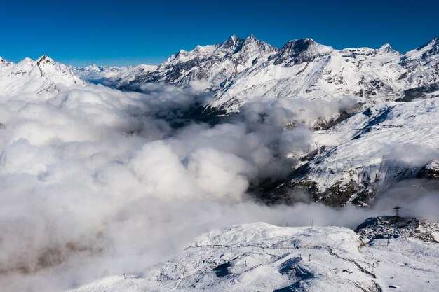 아름다운 구름 아래 눈 덮인 산의 숨막히는 공중 촬영