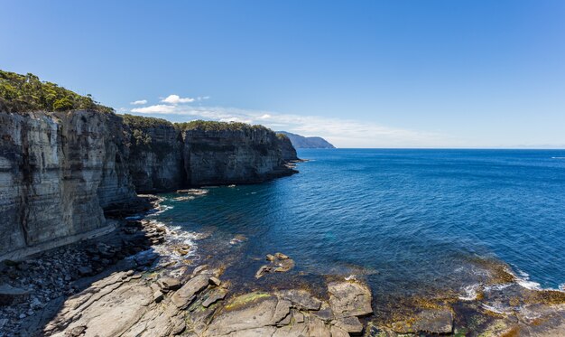 オーストラリアのイーグルホークネックの純粋な水の近くの崖の息をのむようなハイアングルショット