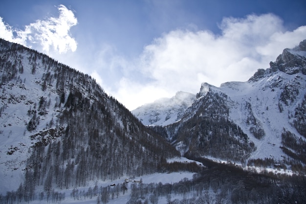 Breathtaking scenery of the snow-capped mountains under a scenic cloudy sky