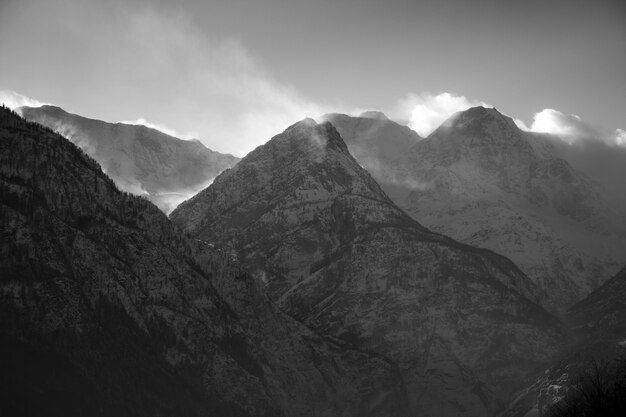 Breathtaking scenery of the snow-capped mountains under a scenic cloudy sky