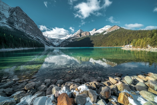 免费照片的拍摄美丽的石头在绿松石水湖和山的背景