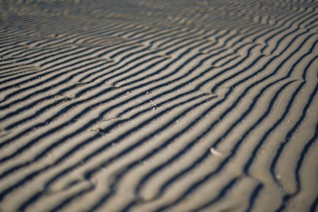 Захватывающий снимок песчаного побережья с красивыми узорами, созданными ветром.