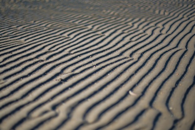 Breathtaking shot of a coastline sand with beautiful patterns made by wind