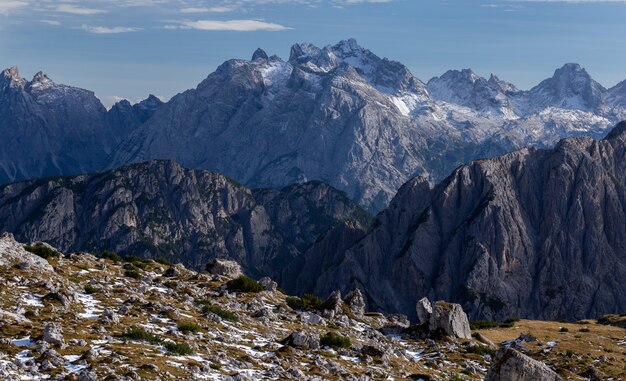 明るい空の下でイタリアアルプスの雪に覆われた岩の息をのむようなショット