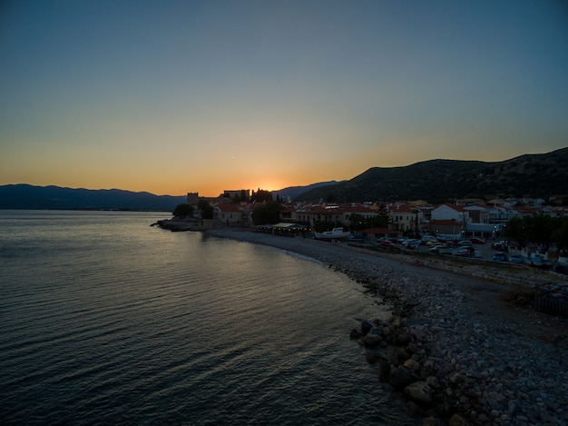 Colpo mozzafiato del sole che sorge sulla spiaggia di samos, in grecia