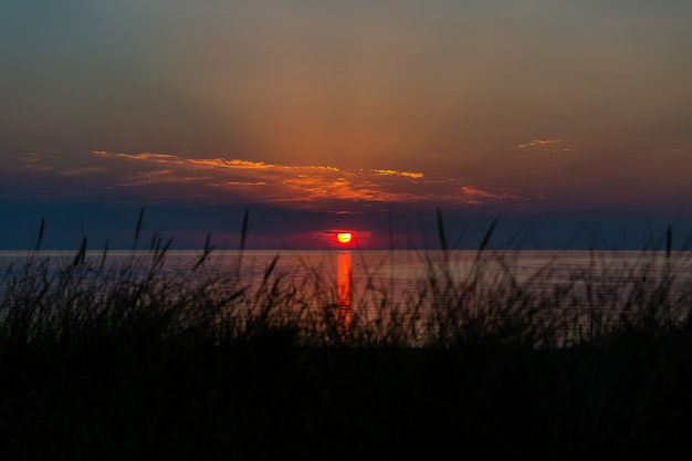 Colpo strabiliante del tramonto sopra la riva dell'oceano a vrouwenpolder, zelanda, paesi bassi
