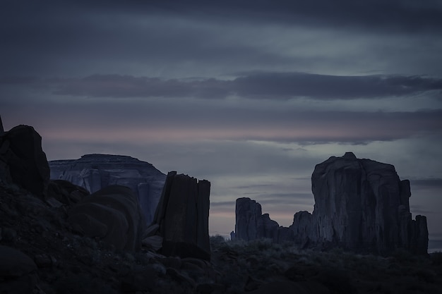Захватывающий закат в облачном небе над каньоном, полным скальных образований.