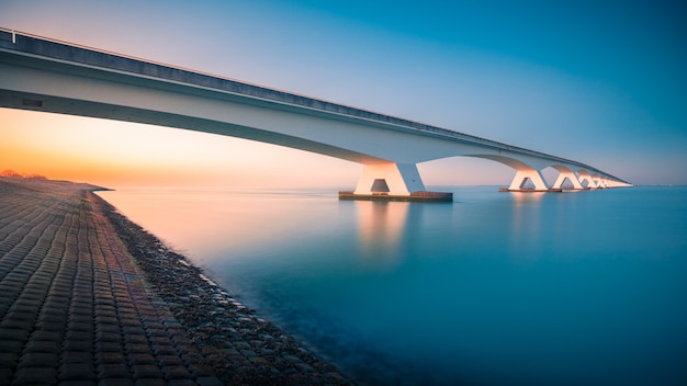 Захватывающий вид на мост через мирную реку захвачен в Zeelandbridge, Нидерланды
