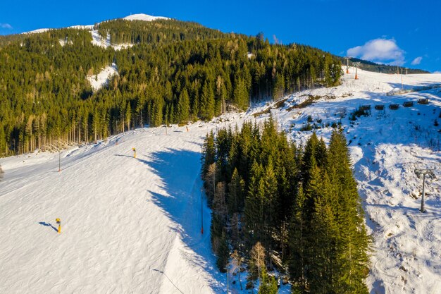 Breathtaking view of forested mountains covered in snow at daytime