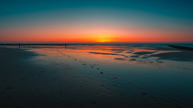 オランダ、ドンブルグの海に沈む夕日の反射の息をのむようなビュー