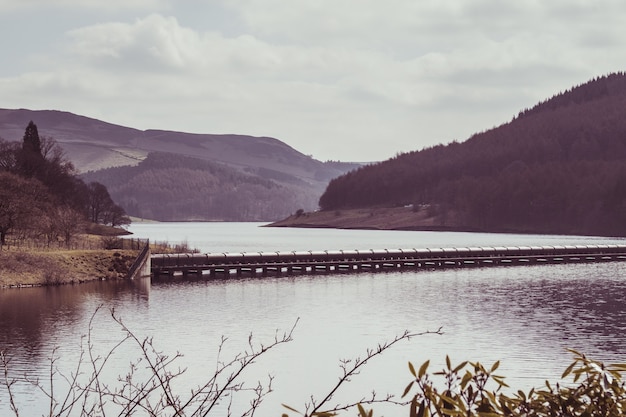 Breathtaking view of a tunnel over the surface of a lake surrounded by tree-covered hills