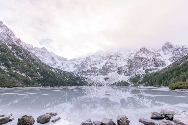 Breathtaking view of winter snowy  mountains and frozen highland lake