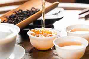 Free photo brewing chinese tea in ceramic gaiwan during the tea ceremony closeup