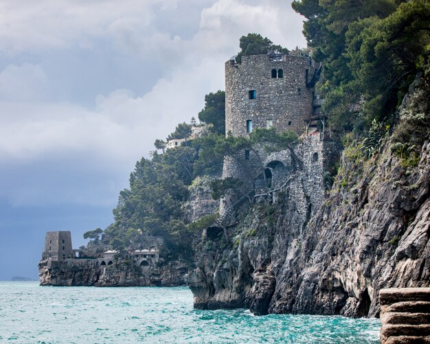 アマルフィ海岸で捕獲された海の上の崖の端にあるレンガ造りの城