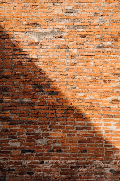 Foto gratuita sfondo di muro di mattoni in luce e ombra