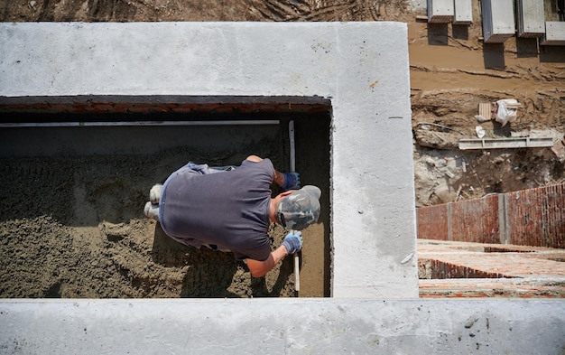 Free photo bricklayer working with sand and doing walls on fresh air