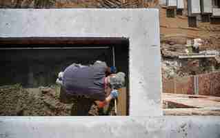Foto gratuita muratore che lavora con la sabbia e fa pareti all'aria aperta