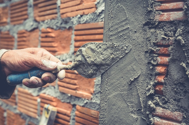 Bricklaying. Construction worker building a brick wall.