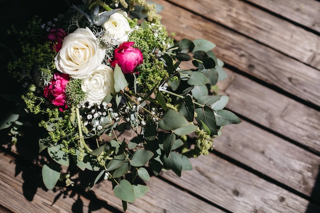 Bridal bouquet lies on a wooden surface