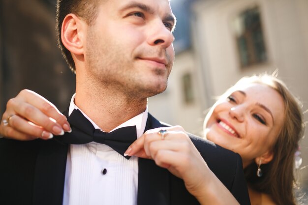 Bride adjusting her boyfriend's bow tie