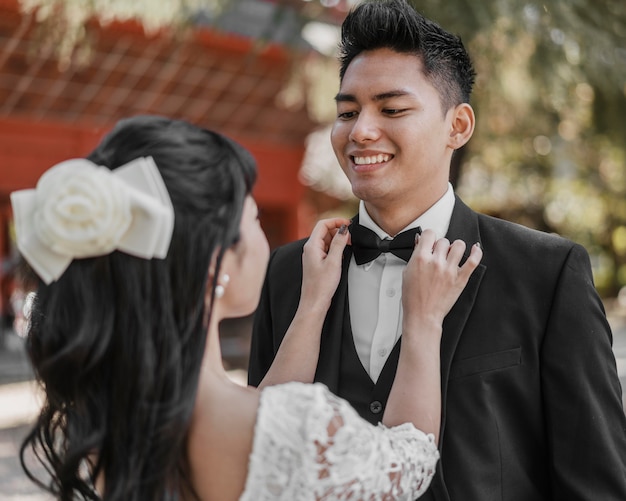 Free photo bride arranging groom's bow tie