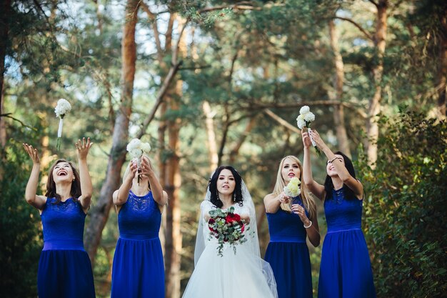 Bride and bridesmaids throwing up bouquets