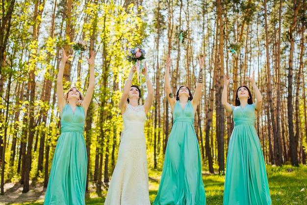 Bride and bridesmaids throwing wedding bouquets. 