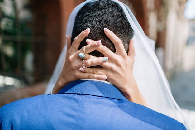 Foto gratuita la sposa attraversa le mani sul capo dello sposo