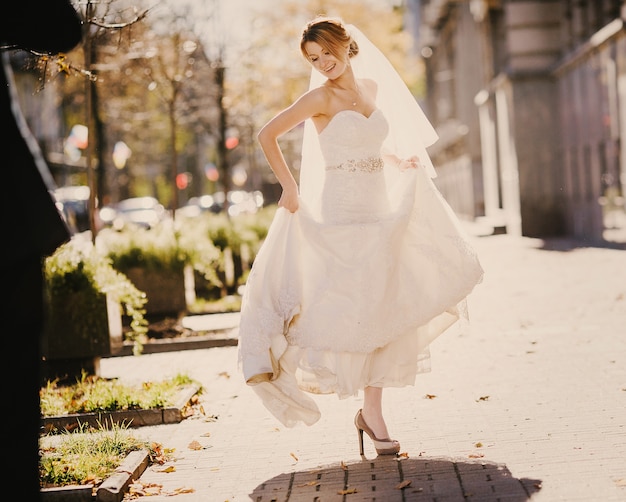 Bride dancing in a park