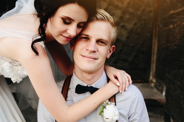 Bride embraces groom with a flower