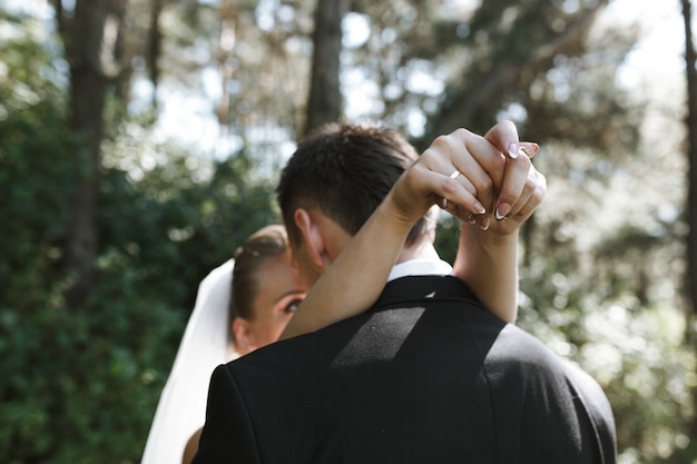 Bride embracing fiance standing outside