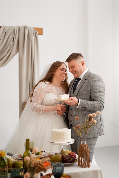 Free photo bride and groom cutting the cake at their wedding