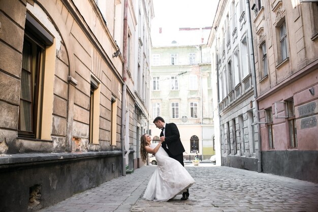Bride and groom dancing on street