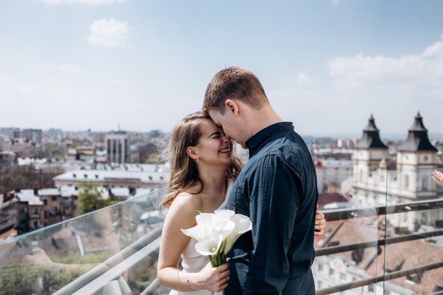 The bride and groom embracing and standing on the ballcony