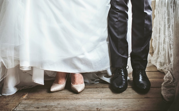 Foto gratuita piedi della sposa e dello sposo nella cerimonia di matrimonio di nozze