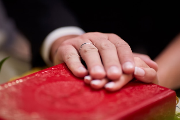 신부와 신랑은 교회에서 약혼식 동안 성경에 손을 잡고