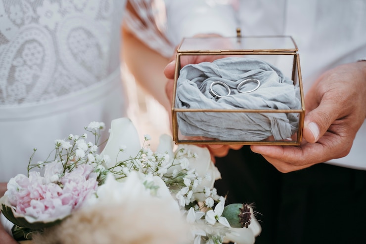 Free Photo bride and groom holding their rings