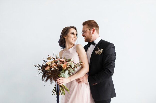 Bride and groom isolated on white wall background.