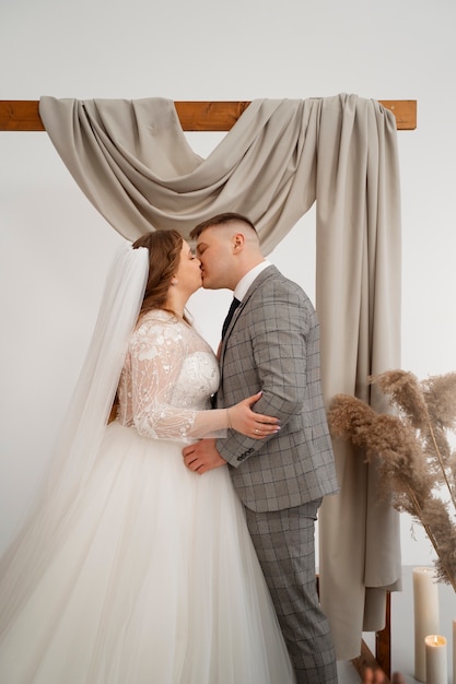 Free photo bride and groom kissing during wedding ceremony