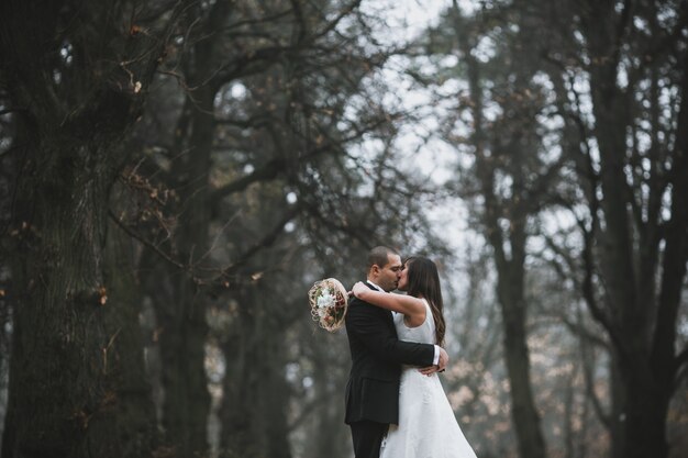 Bride and groom kissing in woods