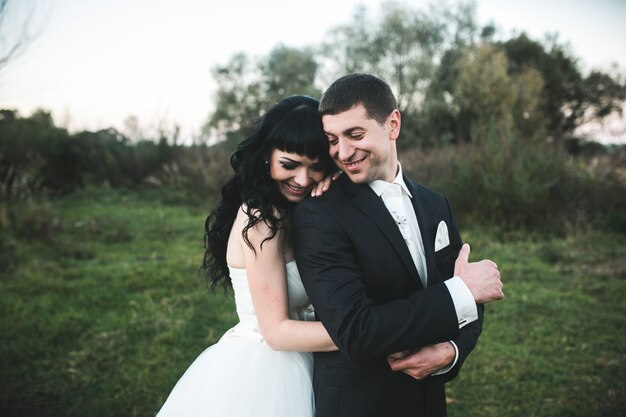 Bride and groom laughing outdoors