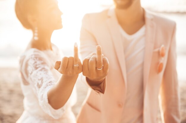 bride and groom posing on the beach at sunset