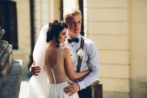 The bride and groom posing in the old street