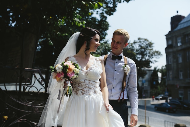 Жених и невеста позируют на улицах старого города