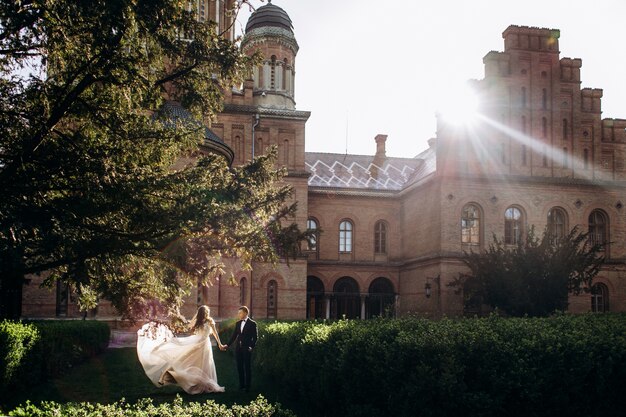 The bride and groom walking along  park