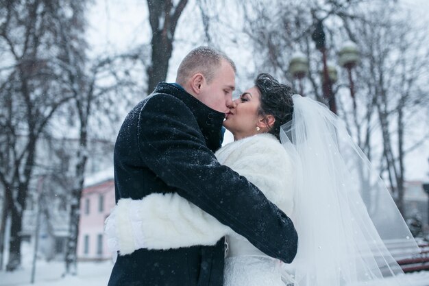 Bride and groom walking on the European city in the snow