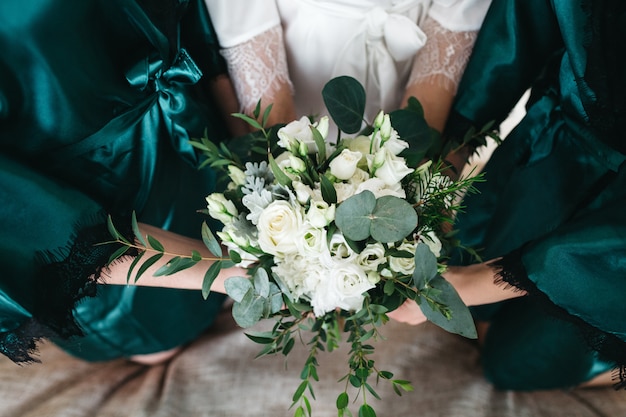 The bride and her friends hold a wedding bouquet