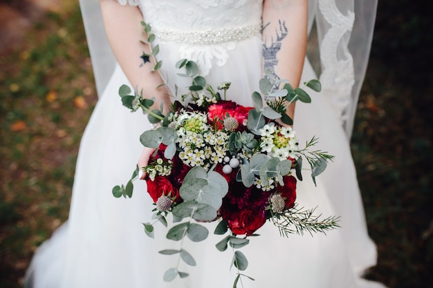 Bride holding bouquet of flowers outside